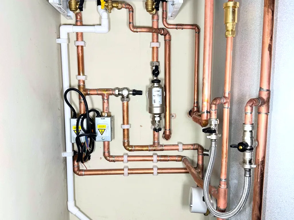 Neat copper pipework around a system boiler and unvented hot water cylinder, fitted by Addisons