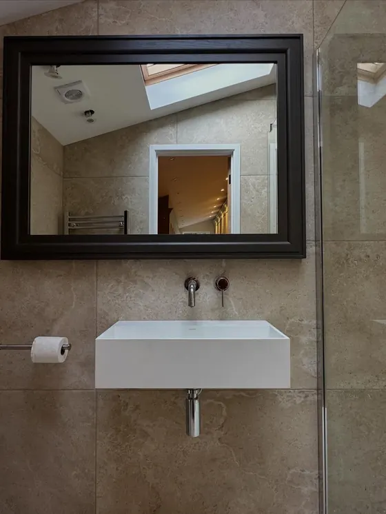 Wall-hung basin with a wall-mounted tap and a large mirror