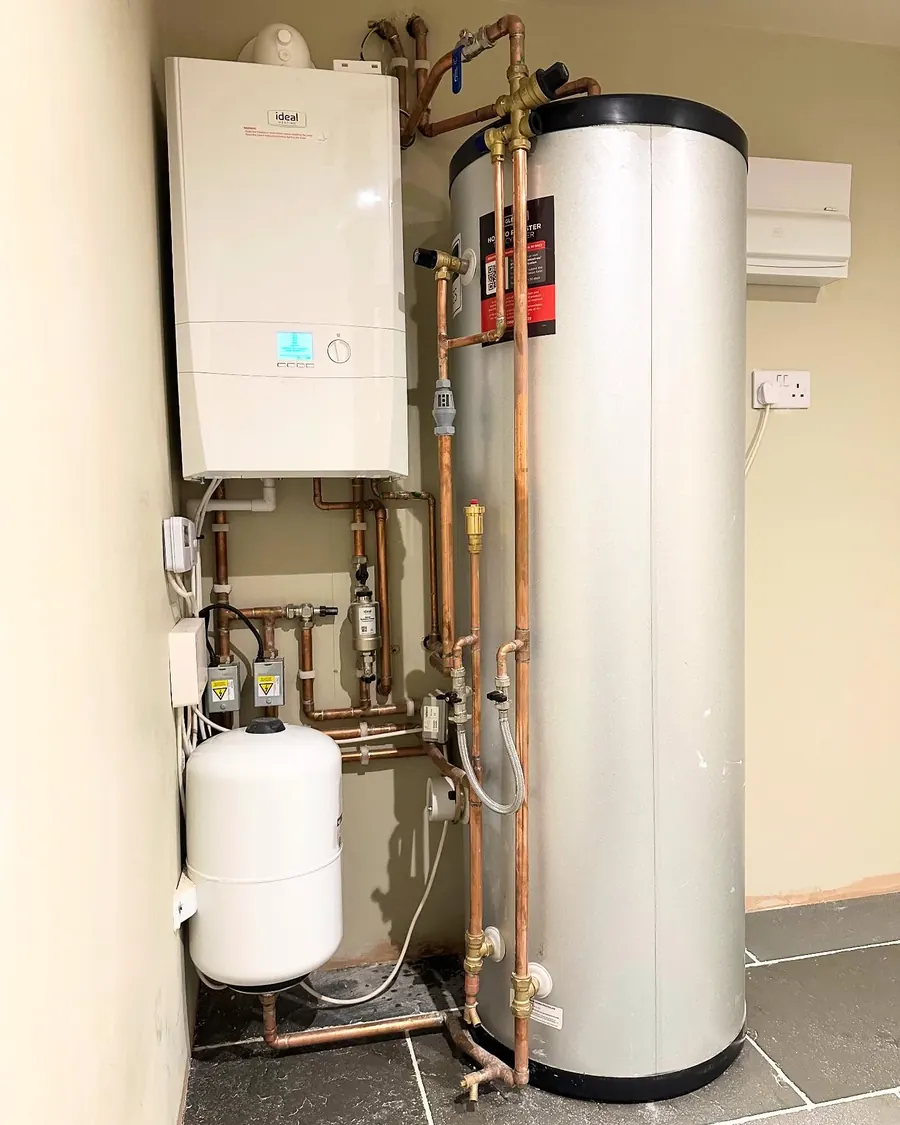 An Ideal boiler beside an unvented cylinder and expansion vessel, with copper pipework